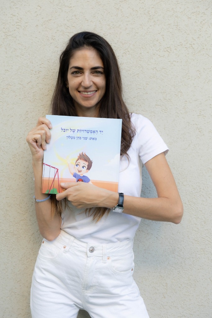 הסופרת שני כהן מטלון מחזיקה את ספרה יד האפשרויות של יובל